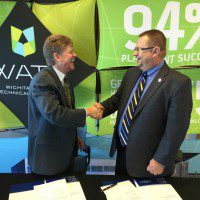 Dr. Tony Kinkel and Dr. Jules Glanzer shake hands after WATC and Tabor College form an articulation agreement