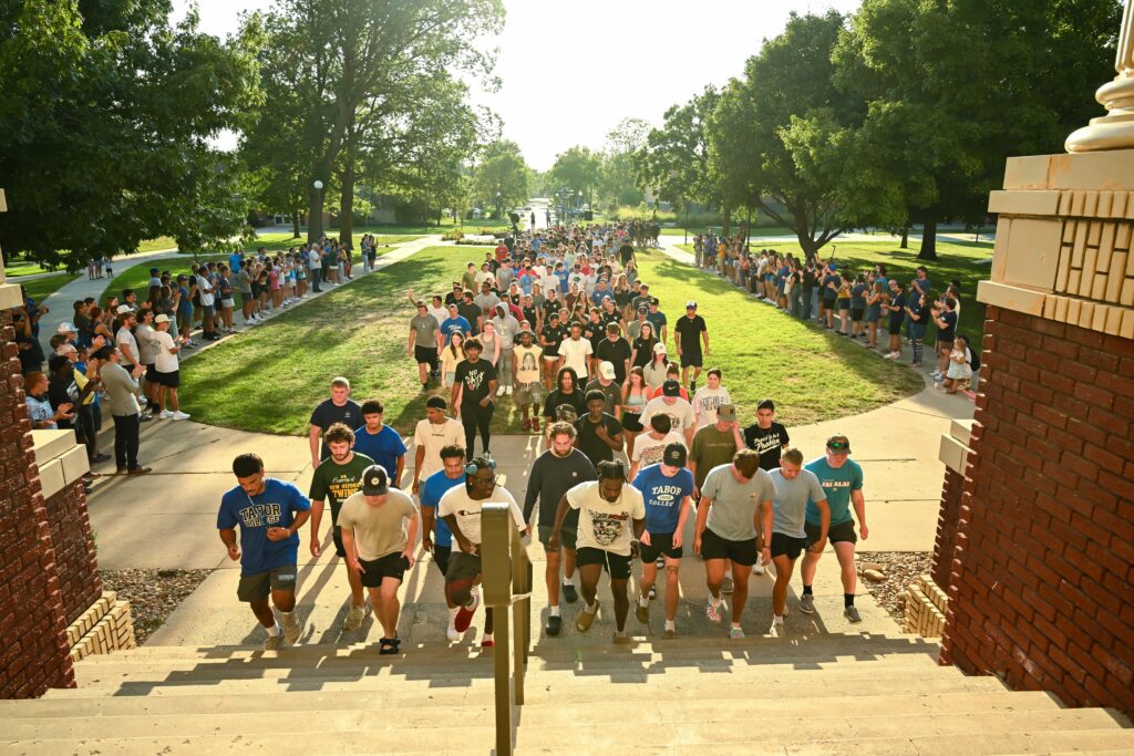 Tabor College Ascent with students walking up front steps of the H.W. Lohrenz Administration Building