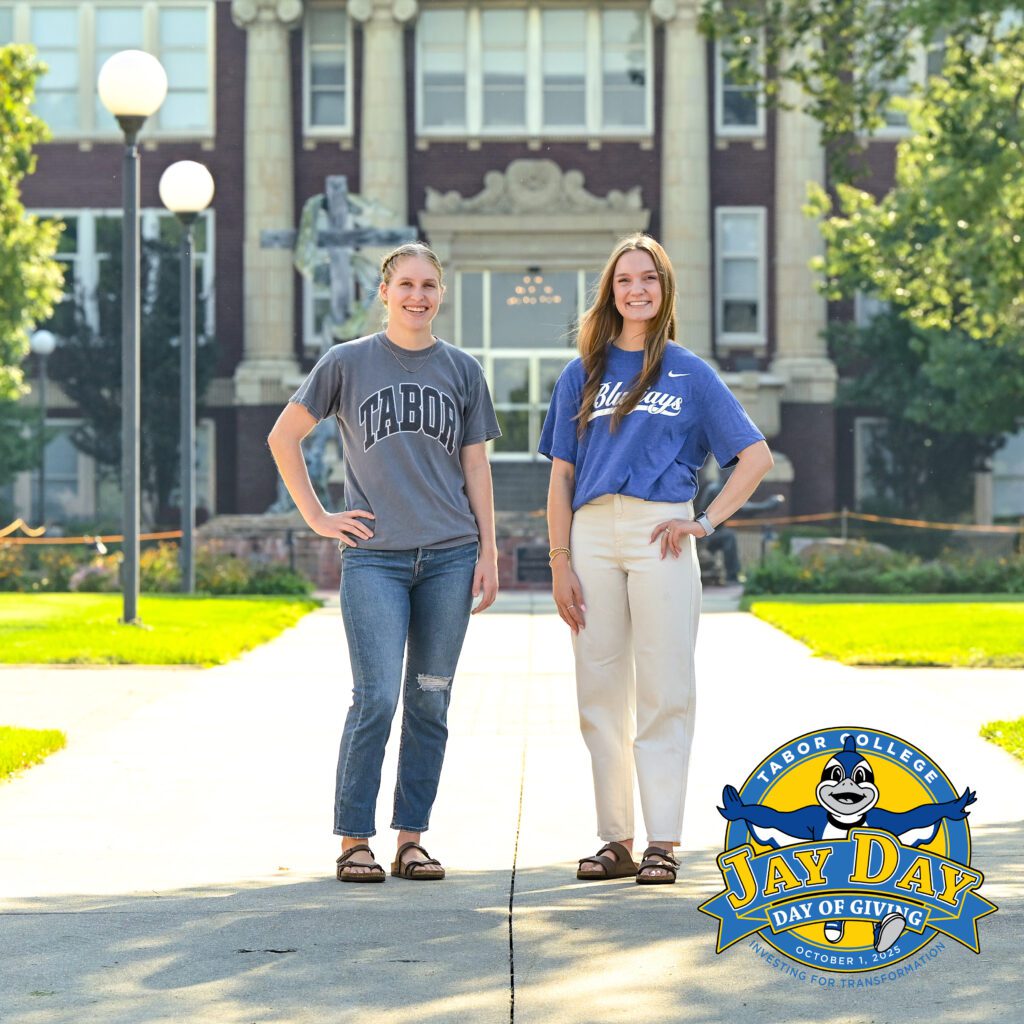 Katie Hofer and Kiana Unruh stand on Tabor campus in front of Lohrenz Building
